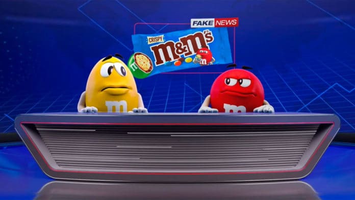 Vermelho e Amarelo em um telejornal mostrando que o M&M's Crispy é fake news.