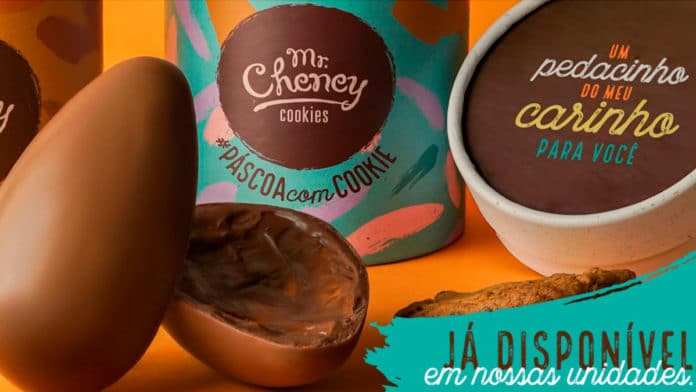 Ovo de Páscoa aberto com latas de cookies atrás, produtos de Páscoa da Mr. Cheney.