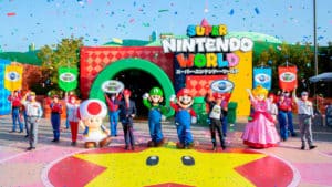 Abertura do Super Nintendo World, com os personagens de Mario e seu criador, funcionários e dono do parque em frente a entrada.