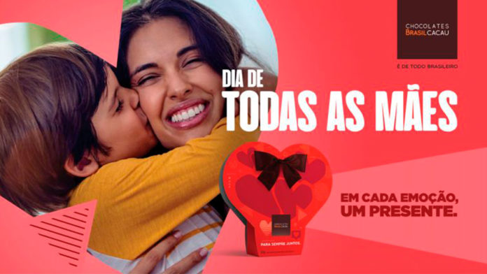 Banner da linha de Dia das Mães da Brasil Cacau. A foto apresenta uma mãe abraçando seu filho, enquanto ele o beija. Ao lado tem o logo da marca junto com as frases