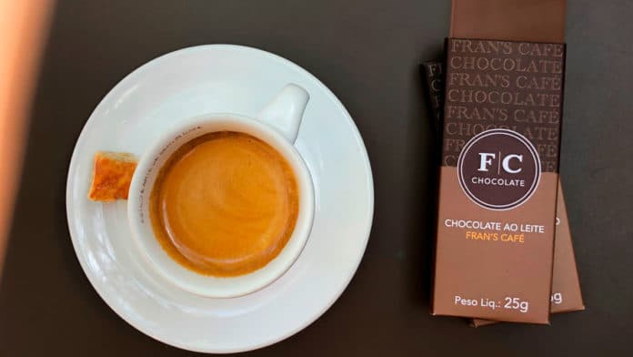 Foto de divulgação da nova linha de chocolates Premium do Fran's Café. A esquerda uma xicara de café e a direita tabletes de chocolate.