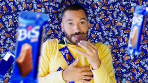 Nova campanha de Bis Xtra com Gil do Vigor. A foto apresenta o Gil deitado em meio a um monte de Bis Xtra, enquanto cai mais chocolate em cima dele e come um dos tabletes.