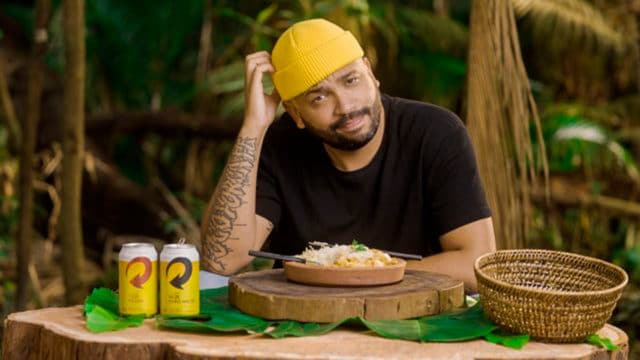 Foto de divulgação do Projota fazendo a prova da comida de No Limite recriada pela Skol.