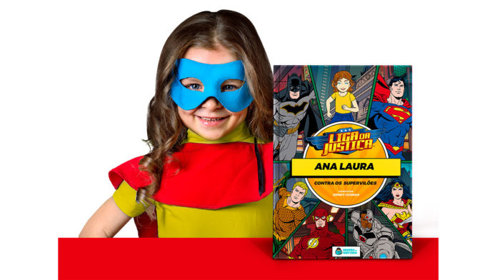 Foto de divulgação dos livros da DC da Dentro da História. A foto apresenta uma menina vestida de super-herói ao lado do livro 