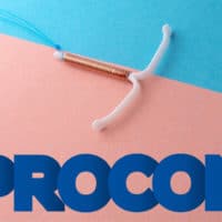 A foto apresenta um DIU em um fundo rosa e azul, com logo do Procon-SP ao lado, instituição que está notificando os planos de saúde.