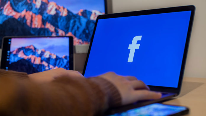 A foto apresenta um computador abrindo o Facebook, que anunciou que a distribuição de posts problemáticos irá diminuir.