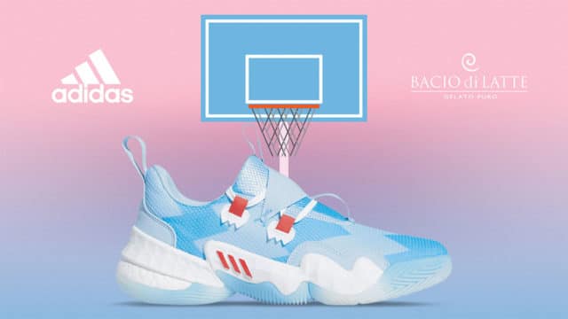 A foto apresenta um fundo degradê de azul e rosa, com o tênis a frente junto de uma cesta de basquete, com os logos da Adidas e da Bacio di Latte, uma de cada lado da foto.