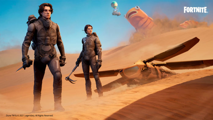 A foto apresenta os protagonistas do filme Duna em um deserto de Fortnite, com uma máquina caída ao lado deles e um monstro ao fundo.