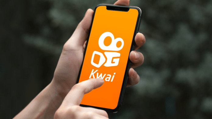 A foto apresenta uma pessoa abrindo o app Kwai para representar a nova plataforma de anúncios da rede social.