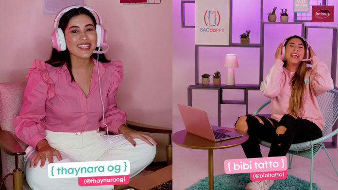 A foto apresenta Thaynara OG e Bibi Tatto em um escritório rosa, sentadas em frente ao um notebook com um headset para responder o SAC da PPK de Intimus.