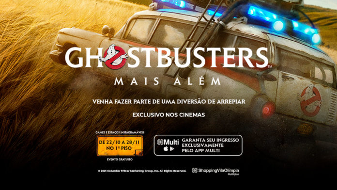 A foto apresenta o banner do espaço de Ghostbusters no Shopping Vila Olímpia, com uma foto do carro junto ao logo do novo filme.