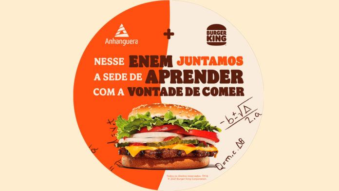 A foto apresenta um anúncio da parceria para o Enem junto com uma foto de um Whopper e os logos da Kroton e do Burger King.