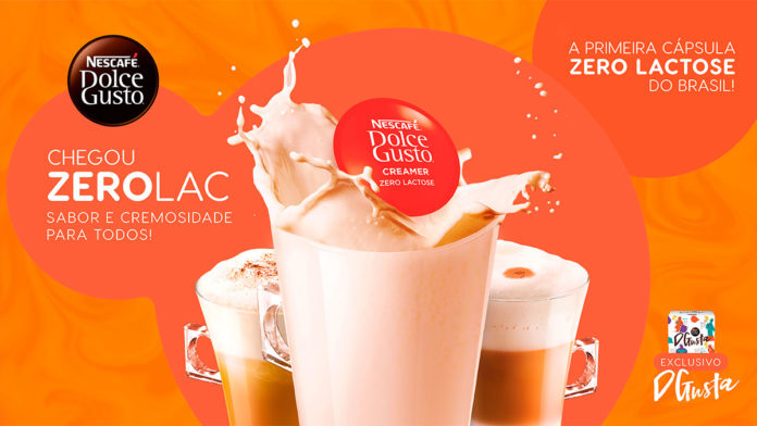 A foto apresenta três copos de café com uma cápsula zero Lactose da Dolce Gusto no meio e o logo da marca no canto superior esquerdo.