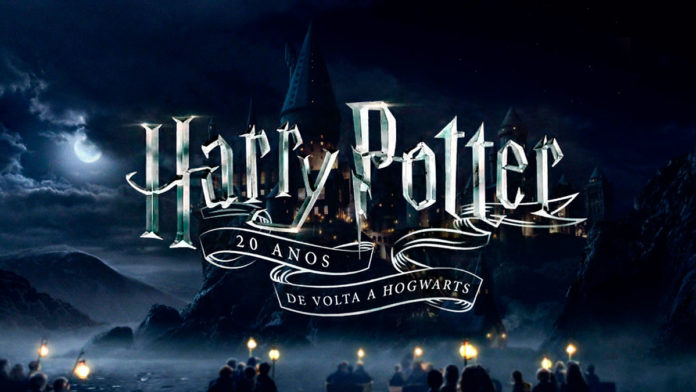 A foto apresenta o logo do especial de 20 anos de Harry Potter da HBO Max, com um fundo dos alunos chegando em Hogwarts durante a noite.