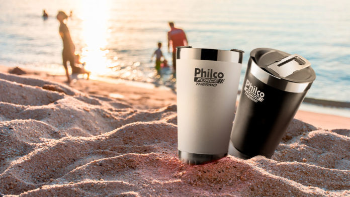 A foto apresenta os novos copos térmicos da Philco no meio de uma praia.