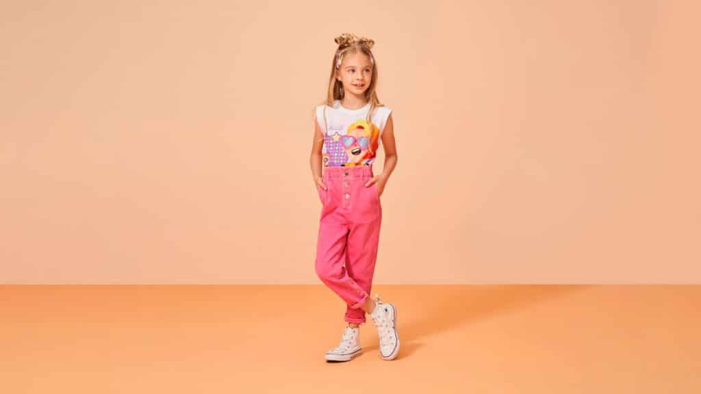 A foto apresenta uma menina usando as novas roupas da coleção Riachuelo x PK XD.