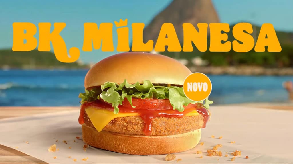 A imagem mostra o sanduíche BK Milanesa em uma mesa de exposição com o Rio de Janeiro ao fundo