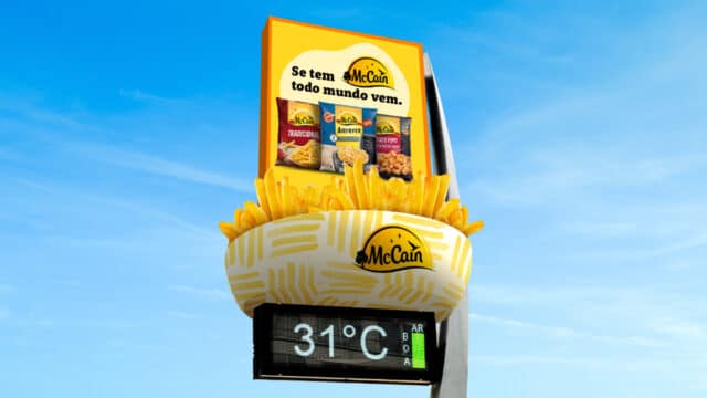 Relógio de Rua onde na parte de cima está uma placa com a mensagem "Se tem McCain, todo mundo vem", seguida de um bowl com batatas fritas fictícias dentro e um relógio de rua logo abaixo mostrando a temperatura de 31ºC