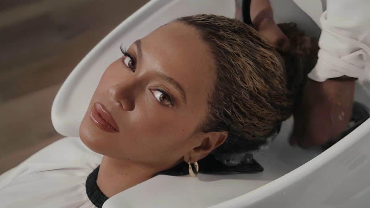 Na imagem, a cantora estadunidense Beyoncé está olhando diretamente para a câmera, enquanto o seu cabelo é lavado em um lavatório. Ela está divulgando a sua nova marca de cosméticos, a Cécred.