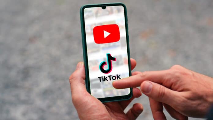 Imagem de um celular mostrando o logo do YouTube e do TikTok