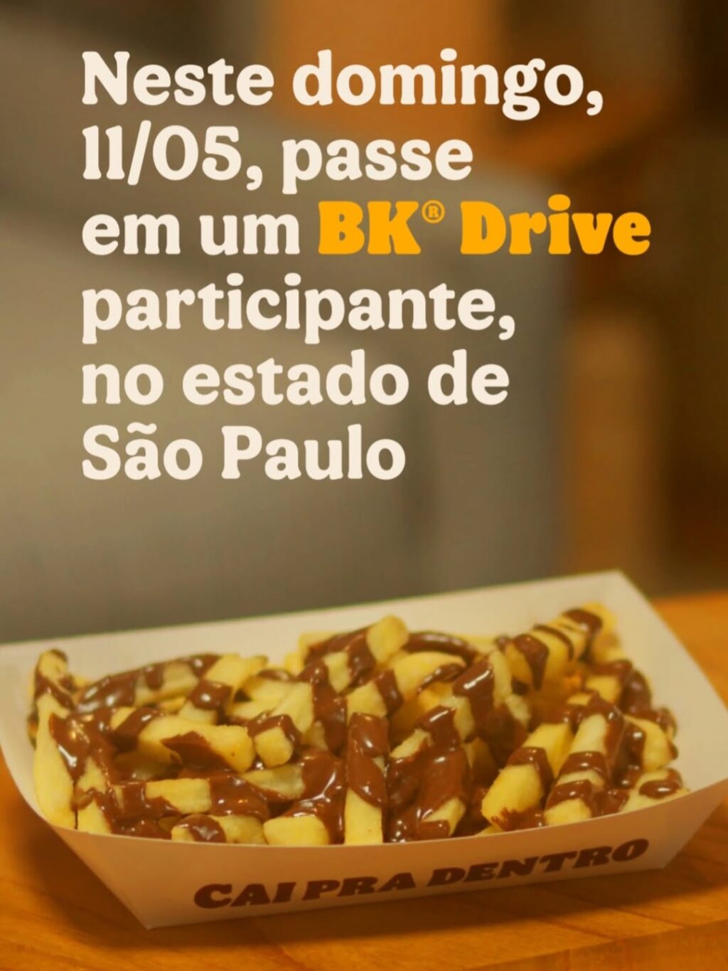 Imagem de batatas fritas cobertas com doce de leite, servidas em uma bandeja com texto promocional sobre a ação do Burger King, destacando o dia 11 de maio em São Paulo.