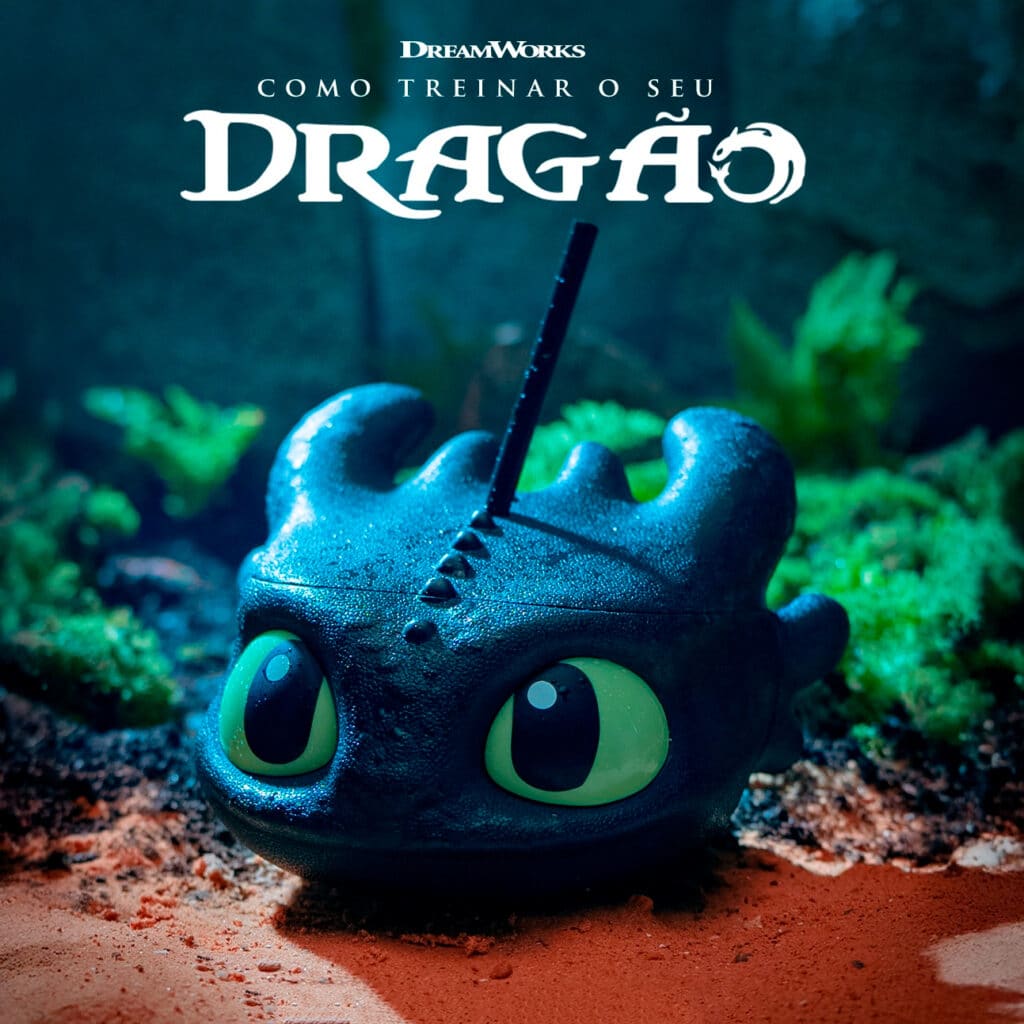 Copo inspirado no dragão Banguela de Como Treinar o Seu Dragão, com detalhes de texturas e olhos verdes, em um ambiente verdejante.