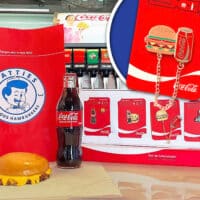 Imagem de um combo de hambúrguer da Patties com batatas fritas, uma garrafa de Coca-Cola e uma embalagem temática da Icebrg contendo pins colecionáveis.