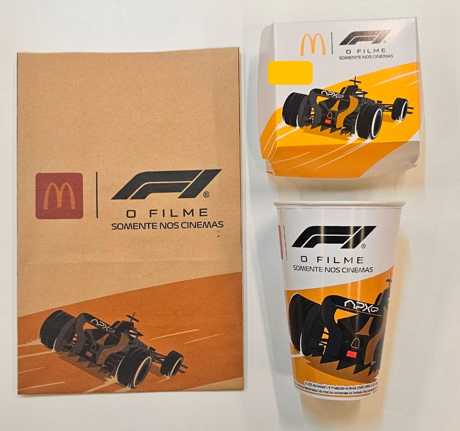 Materiais promocionais do lançamento do filme de Formula 1 no McDonald's, incluindo um copo e uma embalagem com ilustrações de um carro de corrida.