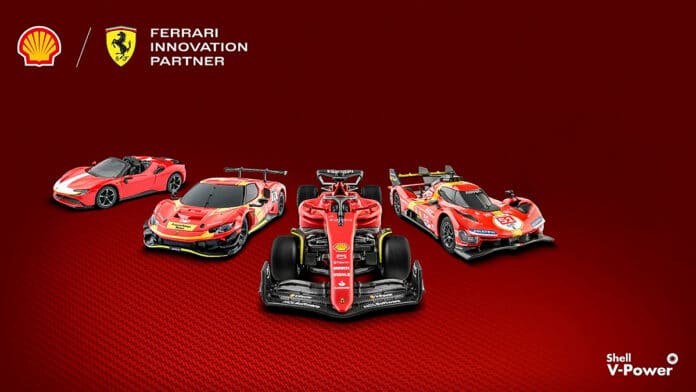 Imagem de quatro miniaturas de carros da Ferrari em um fundo vermelho, destacando a parceria com a Shell. Os modelos visíveis incluem um carro esportivo vermelho, um carro de corrida e outros dois veículos com design esportivo, todos com a marca Ferrari e o logotipo da Shell V-Power.