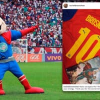 Mascote do Bahia vestido de super-herói em um campo de futebol, sorrindo e fazendo uma pose heroica, com torcedores ao fundo. Ao lado temos um screenshot da publicação de Rachel Bosnahan no Instagram onde exibe a parte traseira da camisa em colaboração da Puma com o Bahia e o filme Superman.