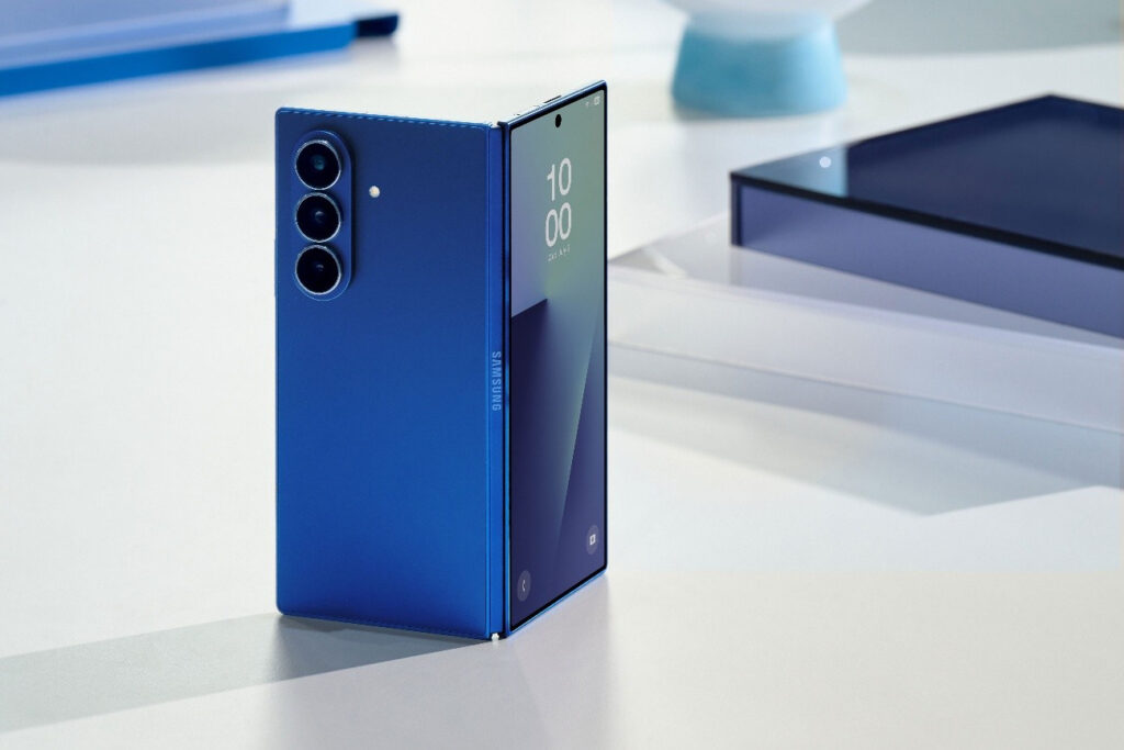 Smartphone dobrável Galaxy Z Fold7 da Samsung em cor azul, exibindo a tela interna AMOLED e câmeras traseiras, em um fundo claro com objetos de design.