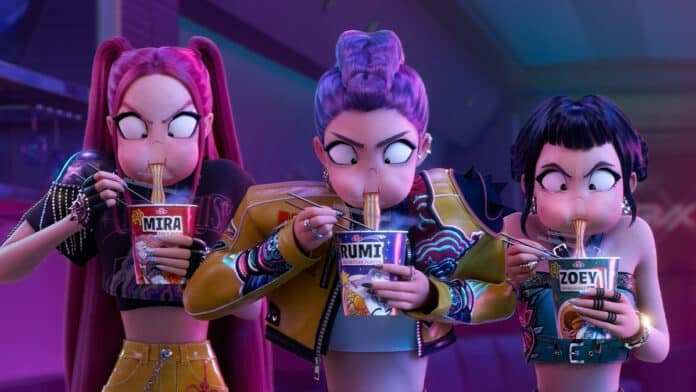 Mira, Rumi e Zoey desfrutando de macarrão instantâneo, com expressões concentradas e envolvidas, em um trecho do filme Guerreiras do K-Pop da Netflix.
