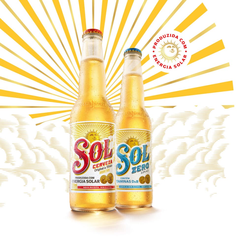 Duas garrafas de cerveja Sol, uma versão regular e outra sem álcool, com fundo amarelo e raios de sol, destacando a produção com energia solar.