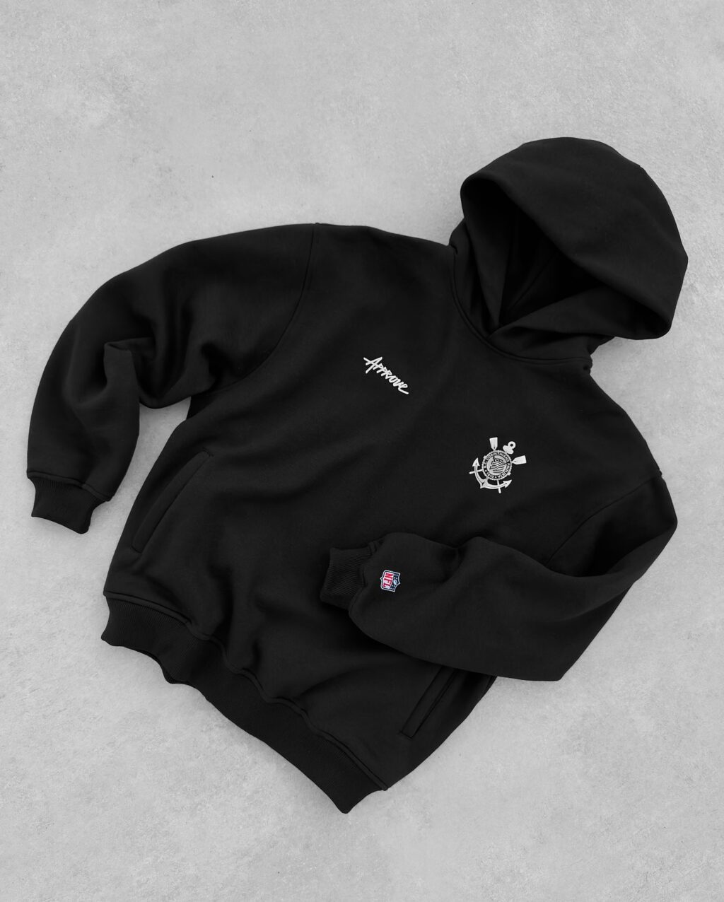 Moletom preto da collab entre a Approve, Corinthians e NFL, com capuz e detalhes em bordado.