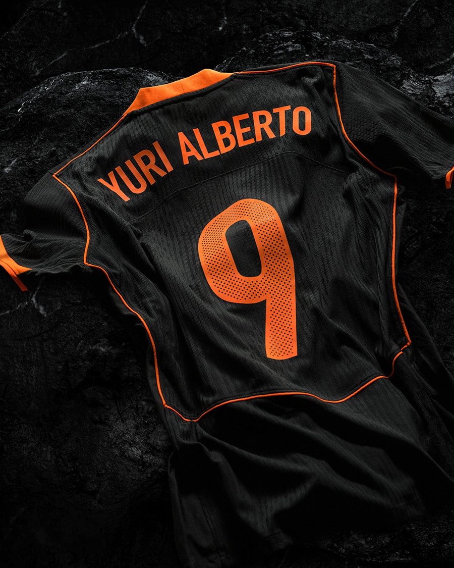 Camisa de futebol do Corinthians, modelo Total 90, na cor preta com detalhes em laranja, mostrando o nome 'YURI ALBERTO' e o número 9 nas costas.