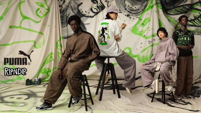 Campanha de moda colaborativa entre Puma e Ripndip. Quatro modelos posam em frente a um fundo com ilustrações em verde neon de gatos estilizados. Eles vestem roupas esportivas e casuais oversized, incluindo conjuntos marrons, moletons cinza, camiseta branca estampada nas costas e camiseta preta com detalhes gráficos verdes. As peças destacam a estética streetwear da coleção.