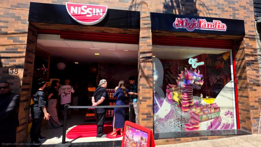 Fachada da loja Miojolândia da Nissin Foods em São Paulo, com decoração temática e clientes na fila de entrada.