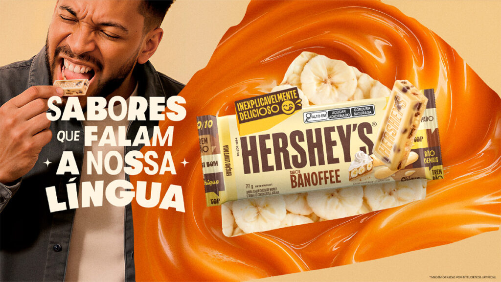 Homem sorrindo enquanto come uma barra de chocolate Hershey's sabor Banoffee, com foco no produto e um fundo cremoso de caramelo. Texto no anúncio destaca 'Sabores que falam a nossa língua'.