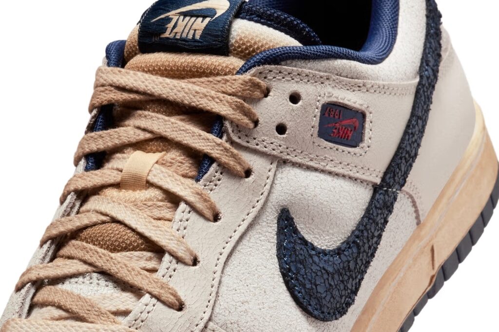 Imagem do Nike Dunk Low inspirado em Stranger Things, destacando o visual desgastado, com efeito vintage, cadarços em tom natural e emblema 'Nike 1987' na lateral.