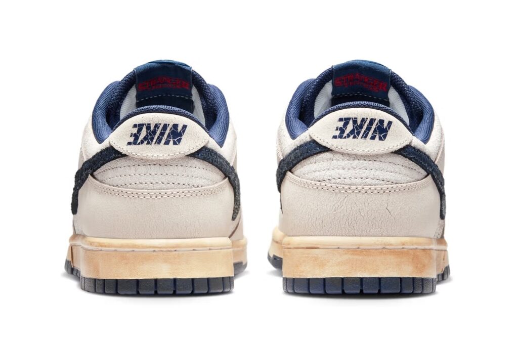 Vista traseira do Nike Dunk Low inspirado em Stranger Things, com logo invertido da Nike e detalhes embelezados que evocam um visual vintage.