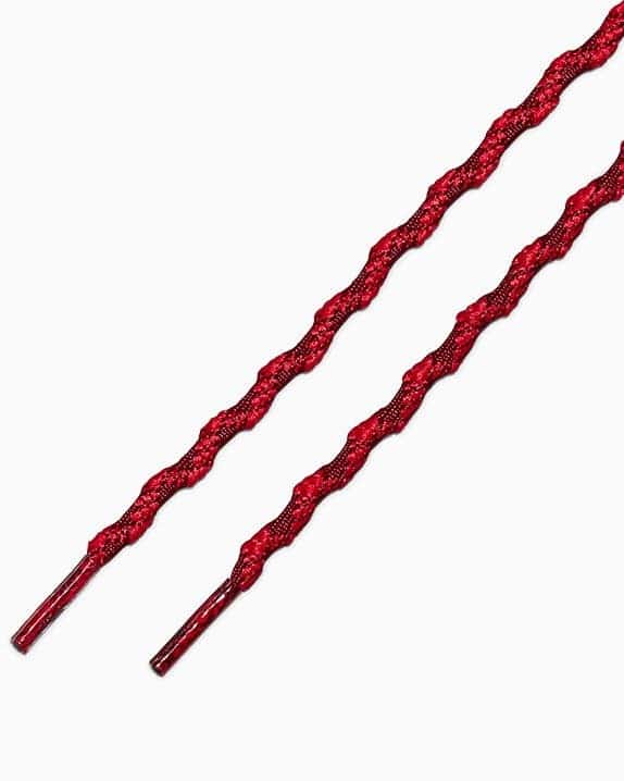 Cadarços em formato ondulado na cor vermelha, projetados para serem usados em tênis, com acabamento texturizado.