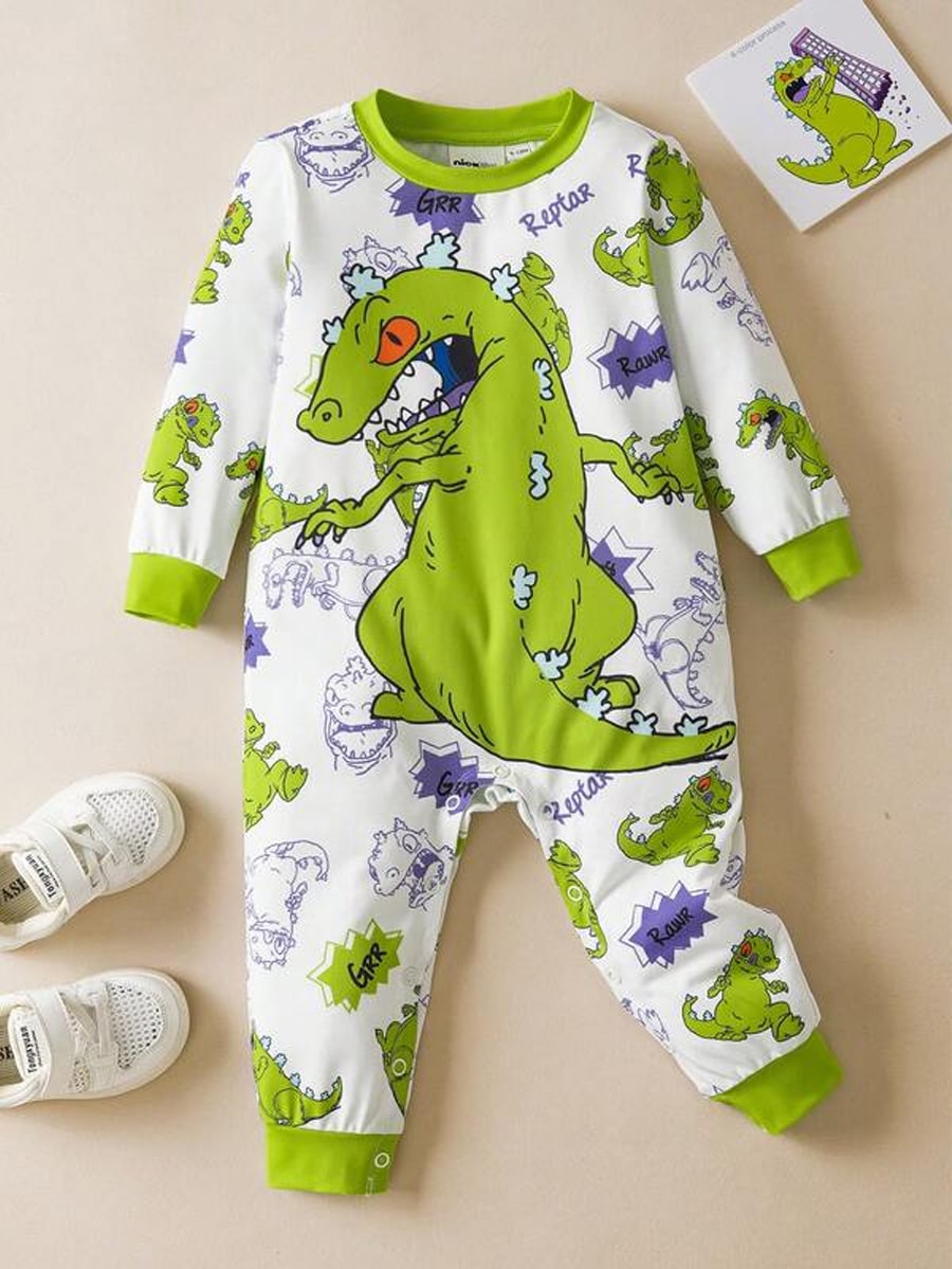 Macacão de bebê com estampas coloridas dos personagens da série Rugrats, incluindo Reptar, em um fundo branco. Ao lado, um par de tênis brancos.