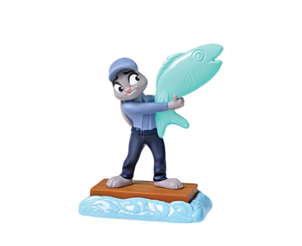 Figurinha do personagem Gary a Cobra, da animação Zootopia 2, segurando um grande peixe enquanto está sobre uma base de madeira.