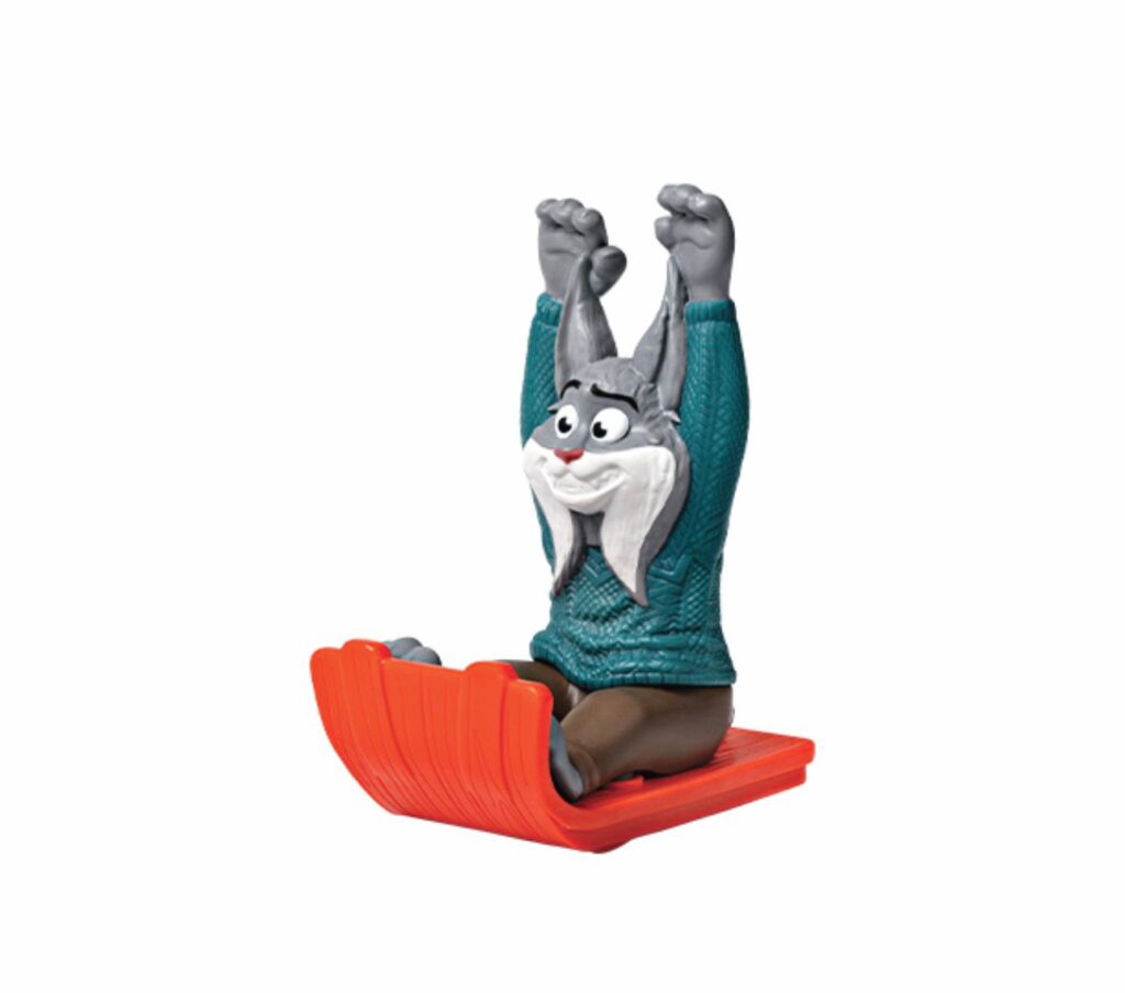 Figura de um personagem de Zootopia em um trenó, com expressão animada e levantando as mãos. O personagem usa um suéter azul e está montado em um trenó vermelho.