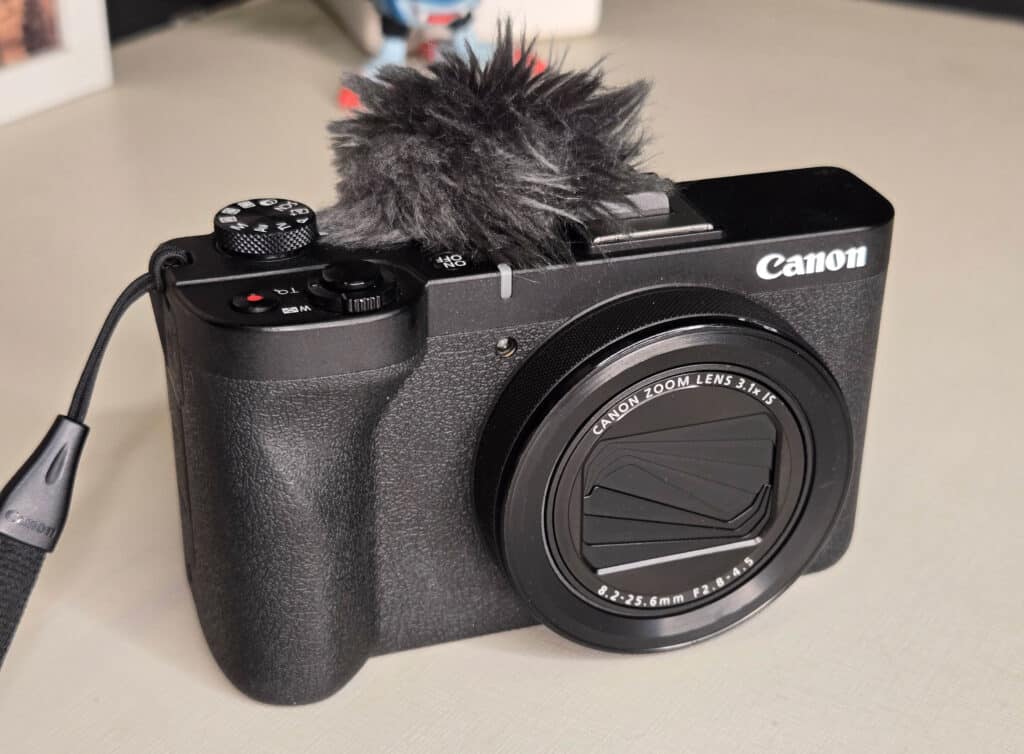 Câmera Canon PowerShot V1 com microfone externo, lente destacada e design compacto.