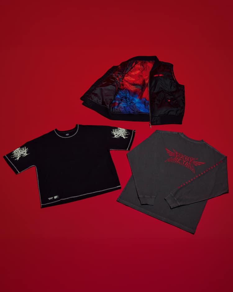 Conjunto de roupas da colaboração entre Babymetal e Vans, apresentando uma camiseta de manga curta preta com designs em ambas as mangas, uma camiseta de manga longa cinza escuro com o logo da Babymetal e um colete reversível MA-1. O fundo é vermelho.