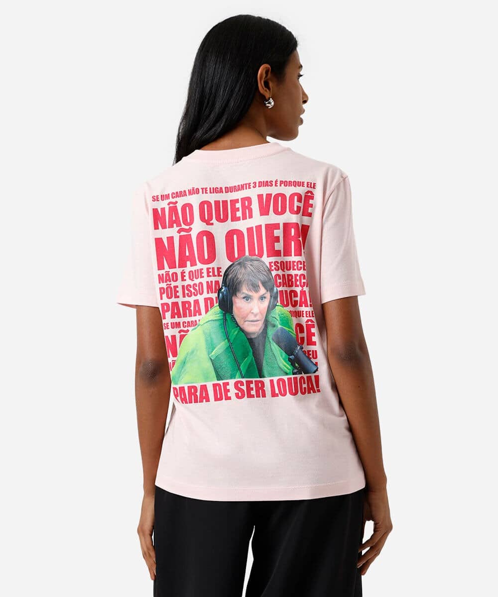 Modelo de camiseta rosa com estampa na parte de trás, apresentando uma mulher com fones de ouvido e bordões populares da astróloga Márcia Sensitiva.