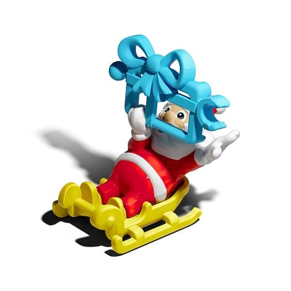 Figura de um Papai Noel em um trenó amarelo, segurando um laço azul em cima da cabeça, com uma expressão sorridente.