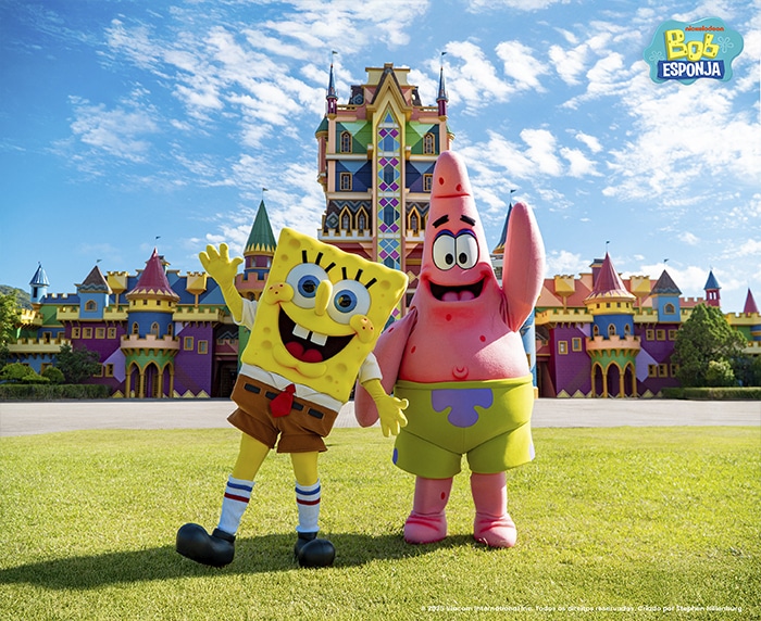 Bob Esponja e Patrick posando felizes em frente a um castelo colorido no Beto Carrero World.