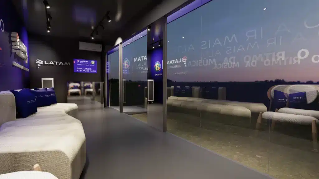 Interior do lounge da LATAM no Planeta Atlântida, com decoração em tons de roxo e branco, sofás confortáveis e painéis de vidro refletindo o horizonte ao fundo. Logos da LATAM e mensagens sobre a experiência musical estão visíveis.